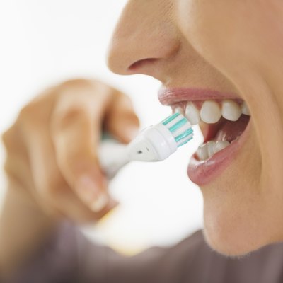closeup on happy young woman brushing teeth