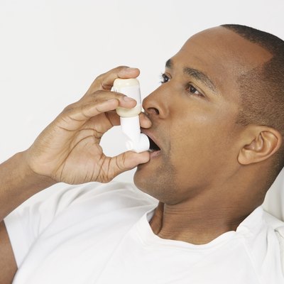 Man using inhaler in hospital bed