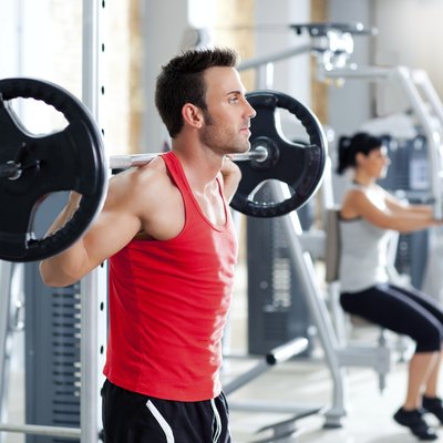 man with dumbbell weight training equipment gym