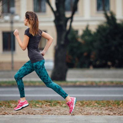 Young girl running outdoors in a city park