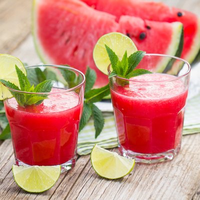 Two glasses with watermelon smoothies with lime and mint