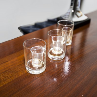 Three empty shot glasses on a bar