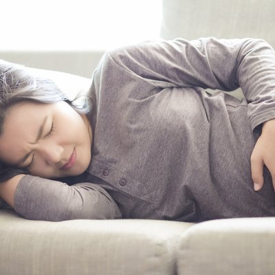 Woman Suffering from Stomachache on Sofa