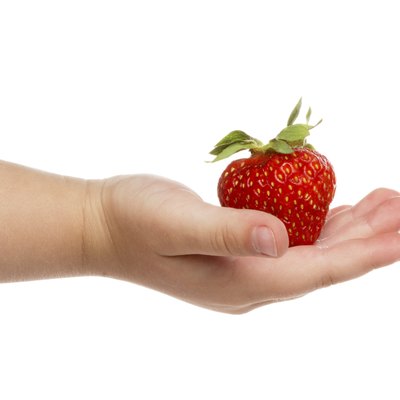 Child's hand with strawberries.
