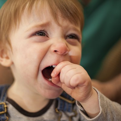 Adorable blond baby crying at home