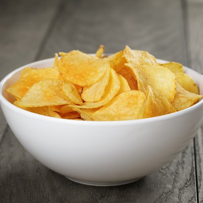 organic potato chips in white bowl on wood table