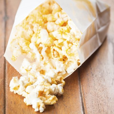 Popcorn paper bag opened with corn spilling out