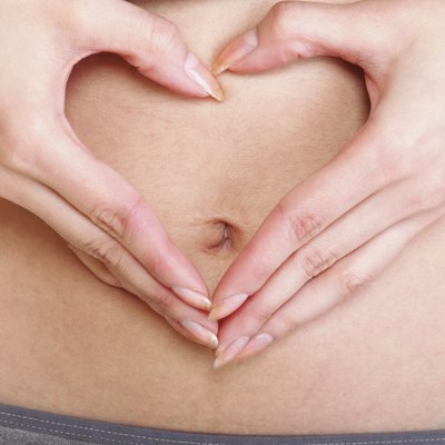 Sexy young woman heart shape hands belly