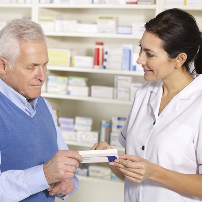 American pharmacist serving senior man in pharmacy
