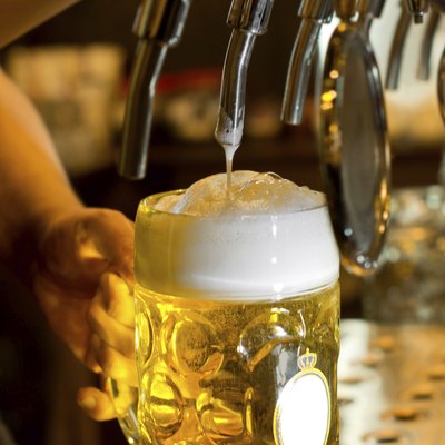 Man pouring a tankard of frothy beer
