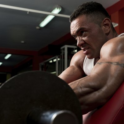Man In The Gym Exercising Biceps With Barbell