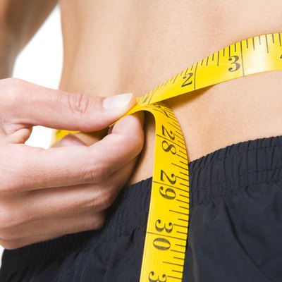 close up photo of a woman measuring her waist