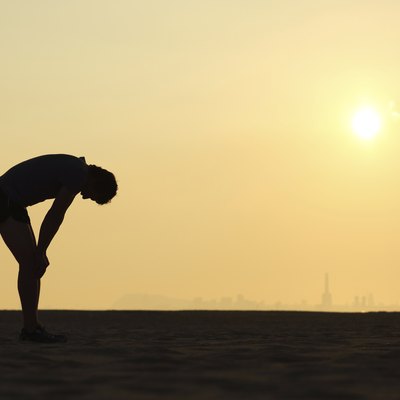 Silhouette of an exhausted sportsman at sunset