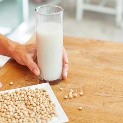 female hand holding a glass of soya milk