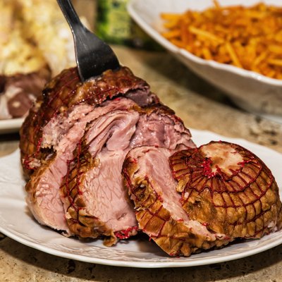 Delicious sliced smoked ham on the white porcelain plate