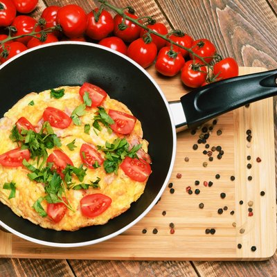 Omelette with ham, tomatoes and chees on the frying pan.