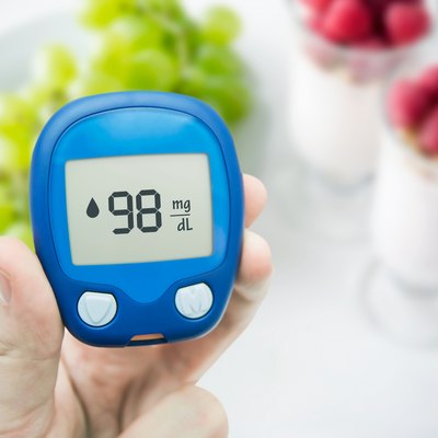 Diabetes doing glucose level test. Fruits in background