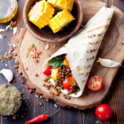 Vegan tortilla wrap, roll with grilled vegetabes, lentil, corn cob.