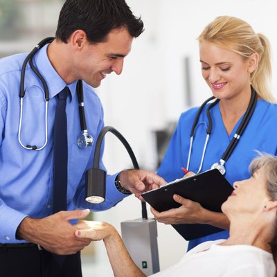dermatologist and assistant recording senior patient's skin condition