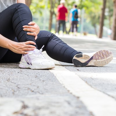 Sports injury. Woman with pain in ankle while jogging