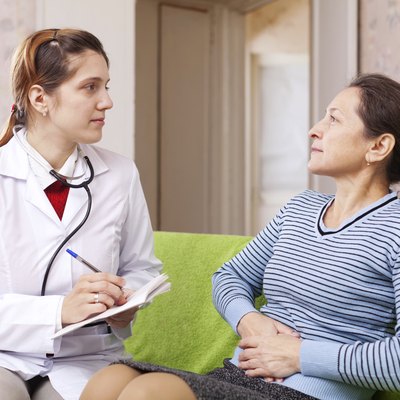 woman complaining to doctor about stitch in side