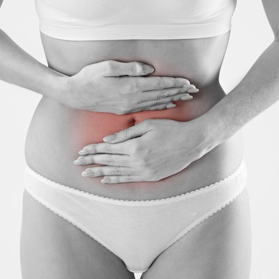 Monochrome Shot Of Woman In Underwear Holding Stomach In Pain