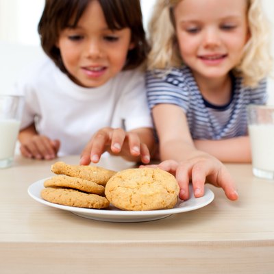 Adorable siblings eating biscuits