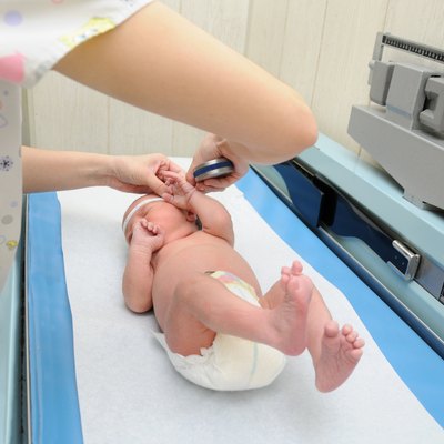 Healthy Newborn Infant on Pediatric Scale Examination Table