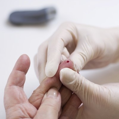 Geriatric nurse measures the blood sugar level of a patient