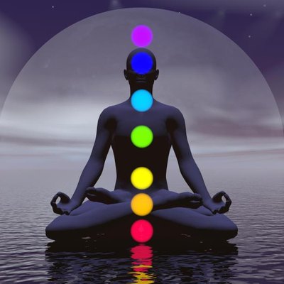 Silhouette of a man meditating with seven colorful chakras upon ocean by full moon dark night
