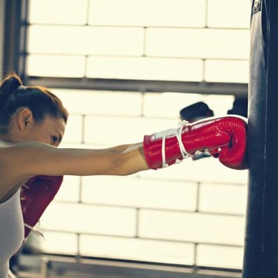 Attractive Female Punching A Bag With Boxing Gloves On
