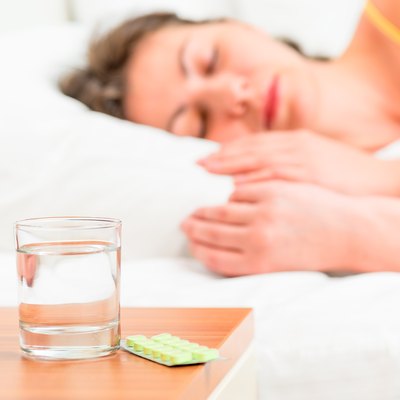 Asleep unhealthy woman and pills on the nightstand