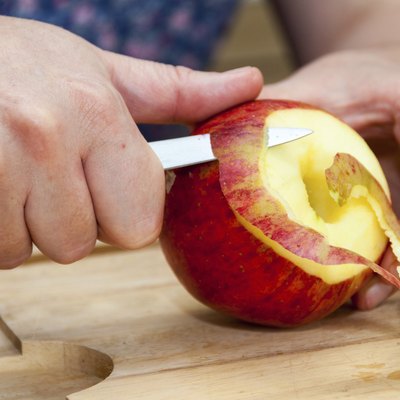 Hands peeling apple