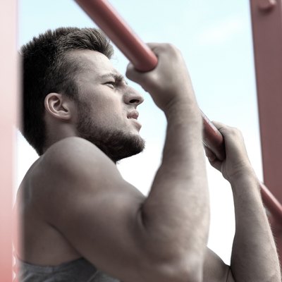 young man exercising on horizontal bar outdoors
