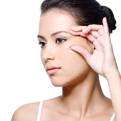 Woman pinching skin near her eye