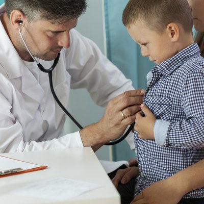Pediatrician examining boy lungs