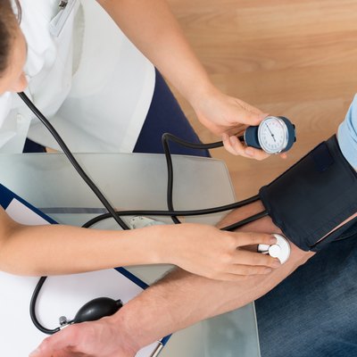 Doctor Measuring Blood Pressure Of Male Patient