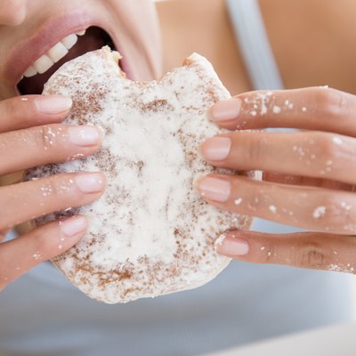 Close up of Hispanic woman eating donut