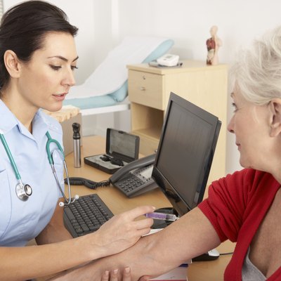 British nurse giving injection to senior woman