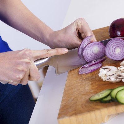 female hands chopping vegetables on a wooden board