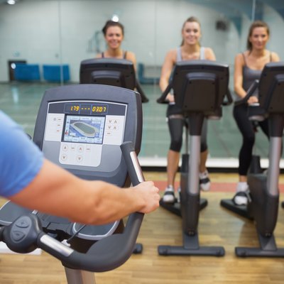 Man teaches Spinning Class to happy women