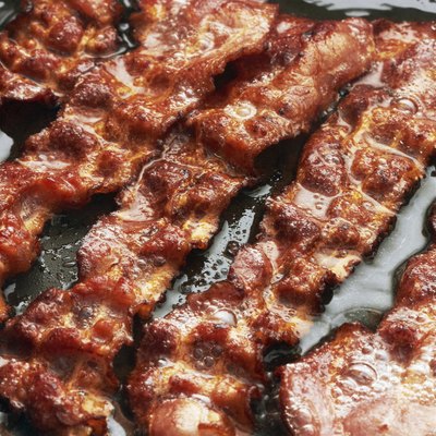 Bacon slice being cooked in frying pan