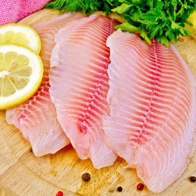 Tilapia with parsley and lemon on board