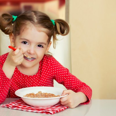 Little girl eating meal.Kid healthy food background.