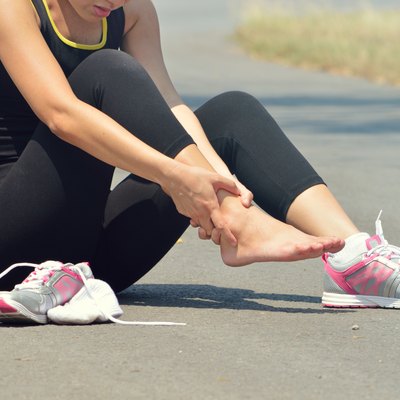 Young woman suffering from an ankle injury while exercising and