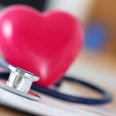 Medical stethoscope head and red toy heart