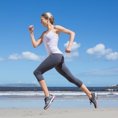 Pretty fit blonde jogging on the beach