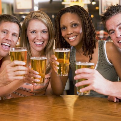 Group of young friends in bar toasting the camera