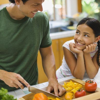 Father and daughter chopping vegetables
