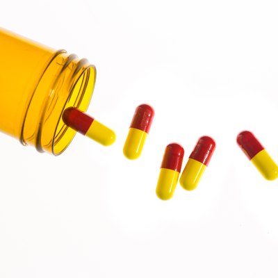 Jar of medicine spilling capsule tablets